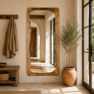 Lifestyle image of a mango wood mirror Bana with tall, arched frame and natural finish. A handcrafted piece of rustic wall art perfect for Mediterranean and minimalist interiors.