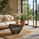 Lifestyle image of a round metal base coffee table with recycled wooden top and woven iron frame; minimalistic style coffee table, 58 cm diameter, 45 cm height.