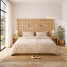 Lifestyle image of a Bansuri hand-carved teak headboard made from an old Indian ceiling door, featuring grid-style floral carvings and a distressed whitewashed finish—an eye-catching piece of old door headboards and old Indian door furniture.