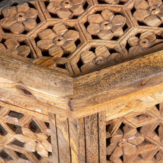 Close up image of a octagonal mango wood coffee table with intricate floral and geometric carvings; durable hand-carved coffee table, 90 × 90 × 46 cm.