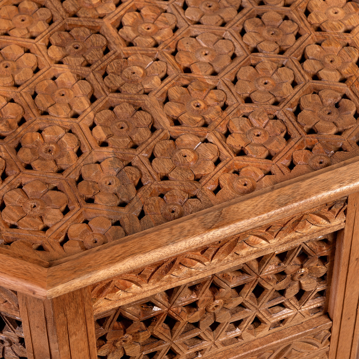 Close up image of a Barkot octagonal mango wood coffee table with intricate floral and geometric carvings; durable hand-carved coffee table, 90 × 90 × 46 cm.