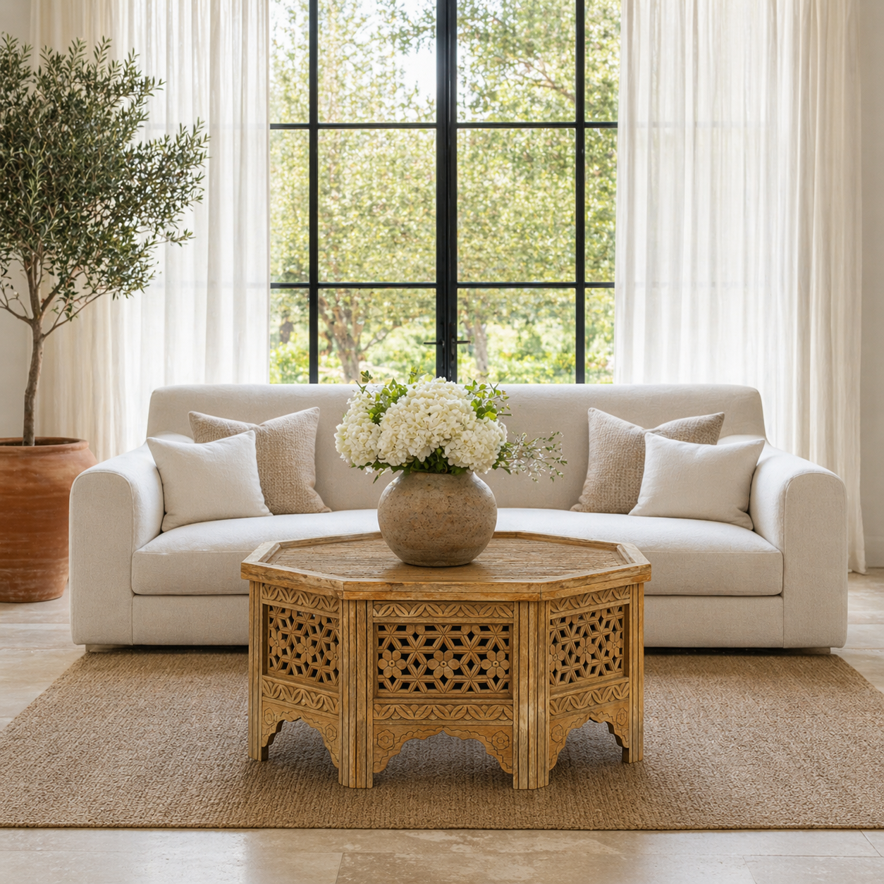 Lifestyle image of a octagonal mango wood coffee table with intricate floral and geometric carvings; durable hand-carved coffee table, 90 × 90 × 46 cm.