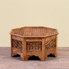 Image of a Barkot octagonal mango wood coffee table with intricate floral and geometric carvings; durable hand-carved coffee table, 90 × 90 × 46 cm.