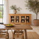 Lifestyle imagination of a hand-carved wooden showcase Barot made from natural mango wood, featuring detailed floral carvings across its front. A sustainable piece of Indian furniture online ideal for living room furniture with a Mediterranean and boho-style design.