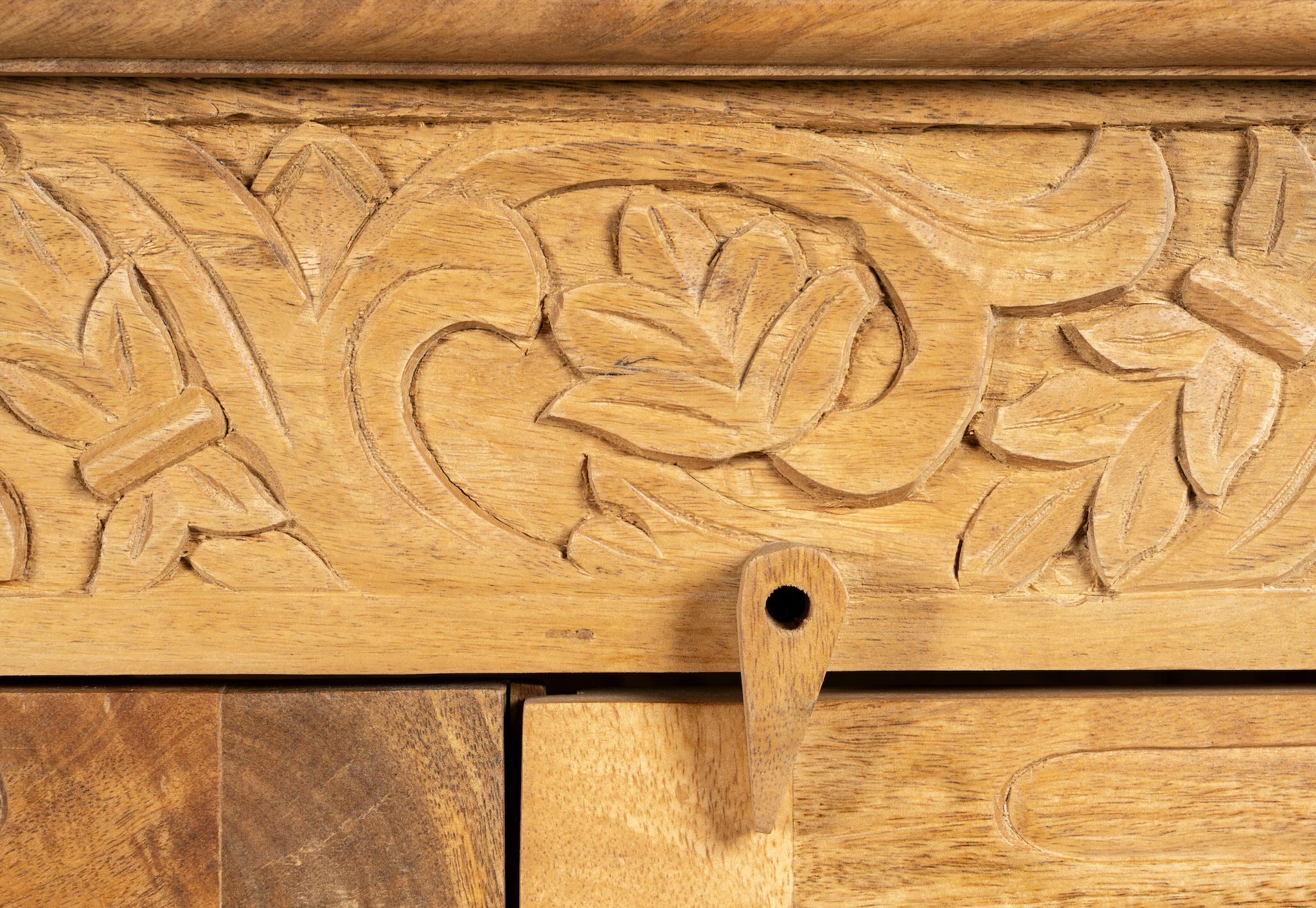 Close up image of a hand-carved wooden showcase Barot made from natural mango wood, featuring detailed floral carvings across its front. A sustainable piece of Indian furniture online ideal for living room furniture with a Mediterranean and boho-style design.