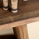 Close up image of a driftwood console table made from reclaimed wood, with lower shelf and weathered finish; sustainable furniture for entryways, 200 × 32 × 80 cm.