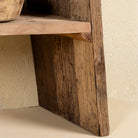 Close up image of a table leg of a driftwood console table made from reclaimed wood, with lower shelf and weathered finish; sustainable furniture for entryways, 200 × 32 × 80 cm.