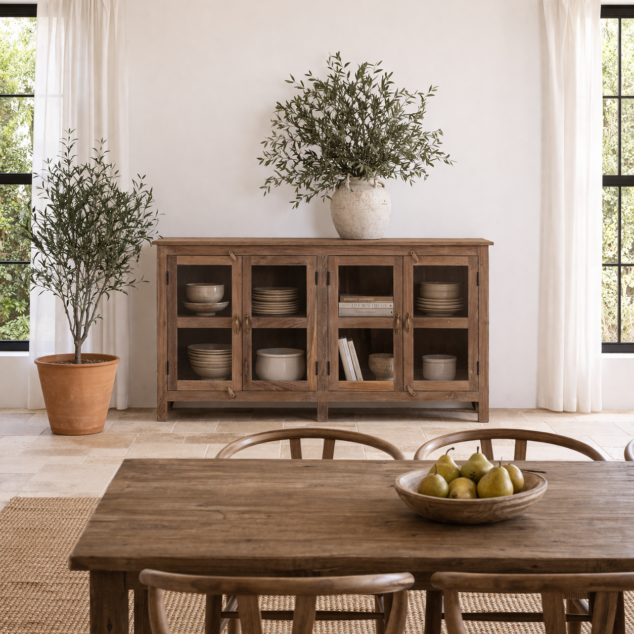 Lifestyle image of a reclaimed wood dresser with four glass doors, teak wood showcase cabinet with brass handles and wooden latches, 170 × 40 × 90 cm.