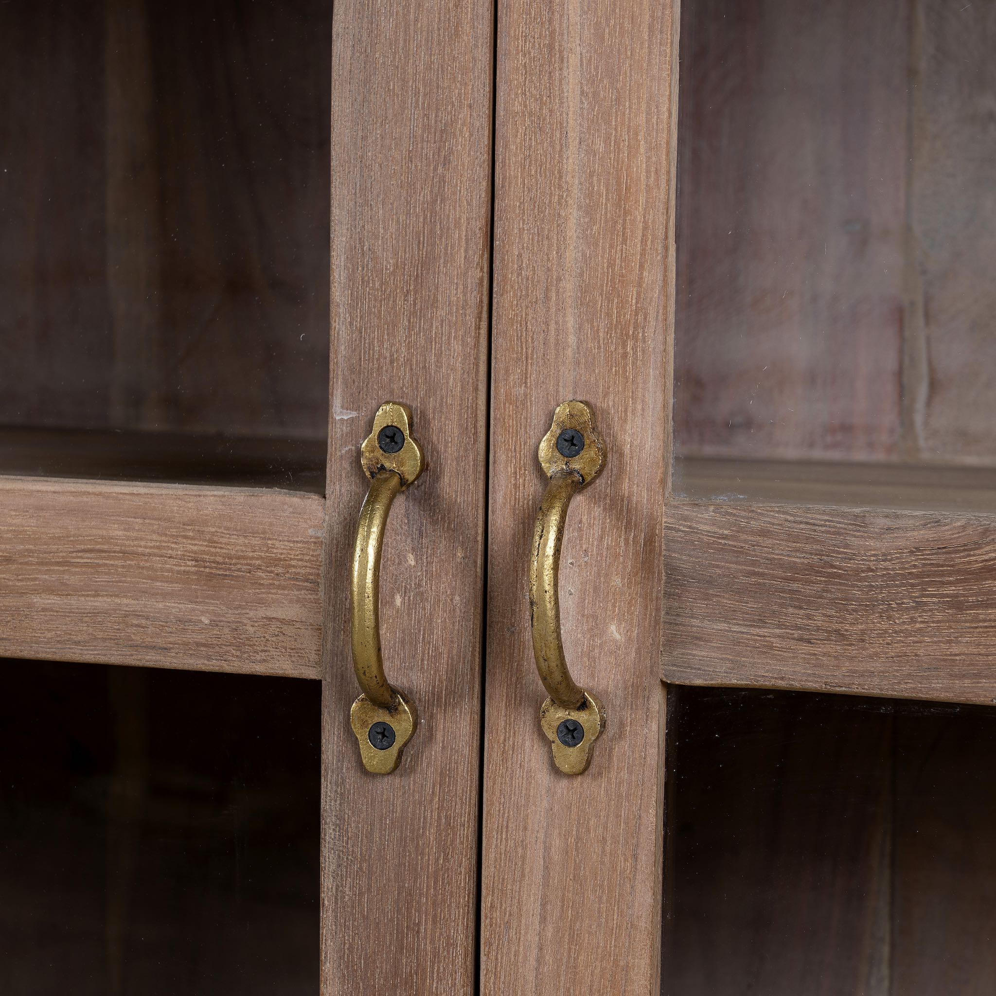Close up image of the handles of a  reclaimed wood dresser with four glass doors, teak wood showcase cabinet with brass handles and wooden latches, 170 × 40 × 90 cm.