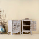 Open door image of a pair of mango wood bedside tables with hand-carved tree motifs and antique finish; perfect bedroom furniture and mango wood furniture, 50 × 70 × 40 cm.