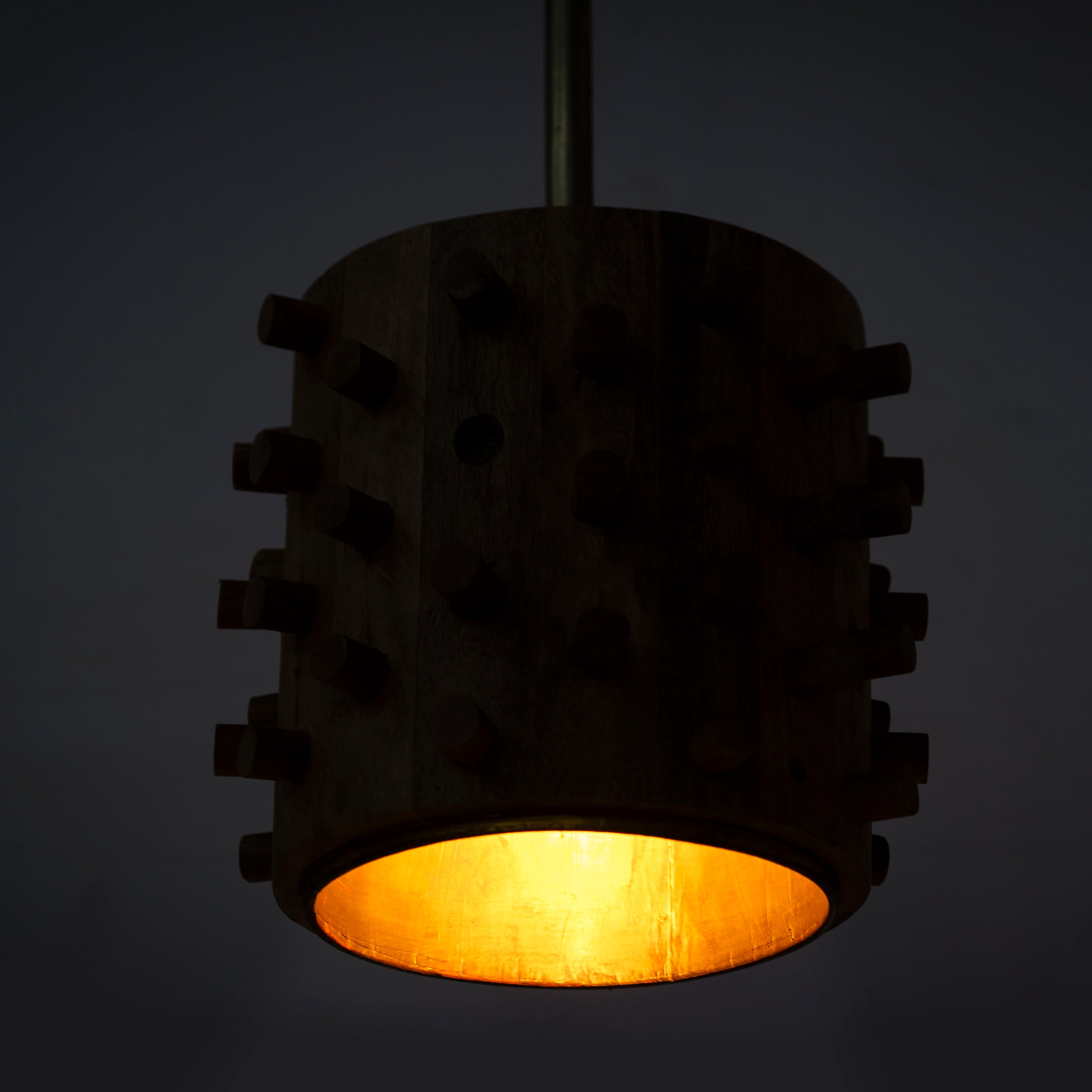 Lighted version of a wooden vintage pendant lamp made from carved mango wood with tree design and brass-plated hanging – a unique piece of mango wood lighting for dining rooms, living spaces, or entryways.