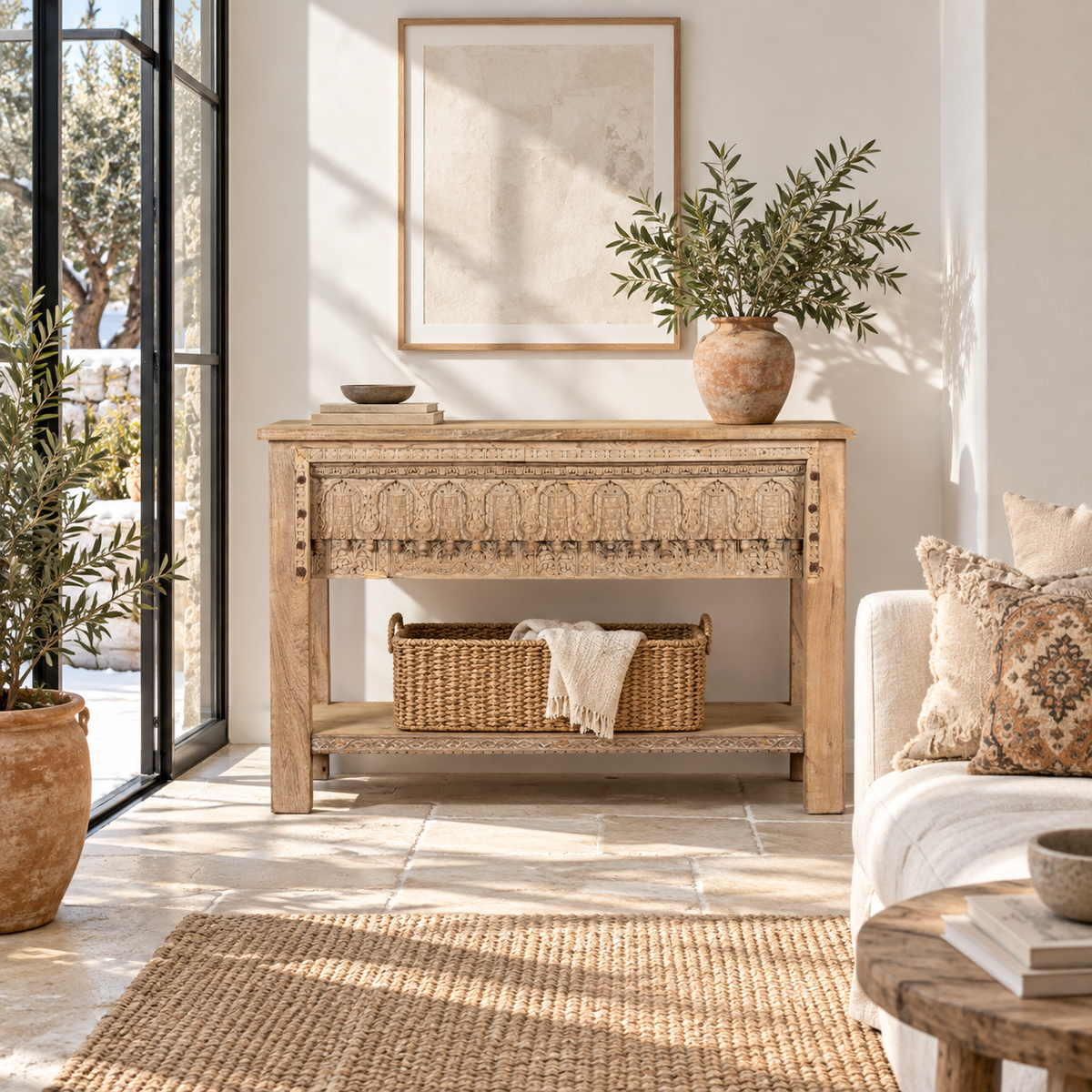 Lifestyle image of a Bhaskar reclaimed teak wood console table with carved old Indian house elements and lower storage shelf 118cm.