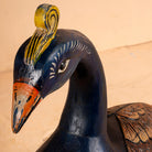Close up image of a hand-painted mango wood peacock decor – Indian home accessory from Rajasthan, ideal for vintage home decor and artistic interiors.