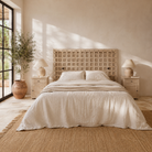 Lifestyle image of a Bheem hand-carved teak headboard made from an old Indian ceiling door, featuring floral panel carvings and a whitewashed finish—an authentic piece of old door headboards and old Indian door furniture.