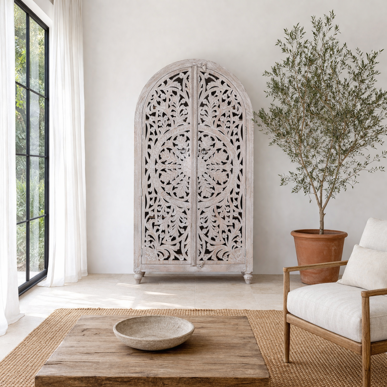 Lifestyle imagination of a of a Bhuvana arched mango wood wardrobe featuring a sculptural half-round design, intricate hand-carved floral detailing, and carved legs—an artisanal piece in the collection of arched wardrobes and mango wood wardrobes.