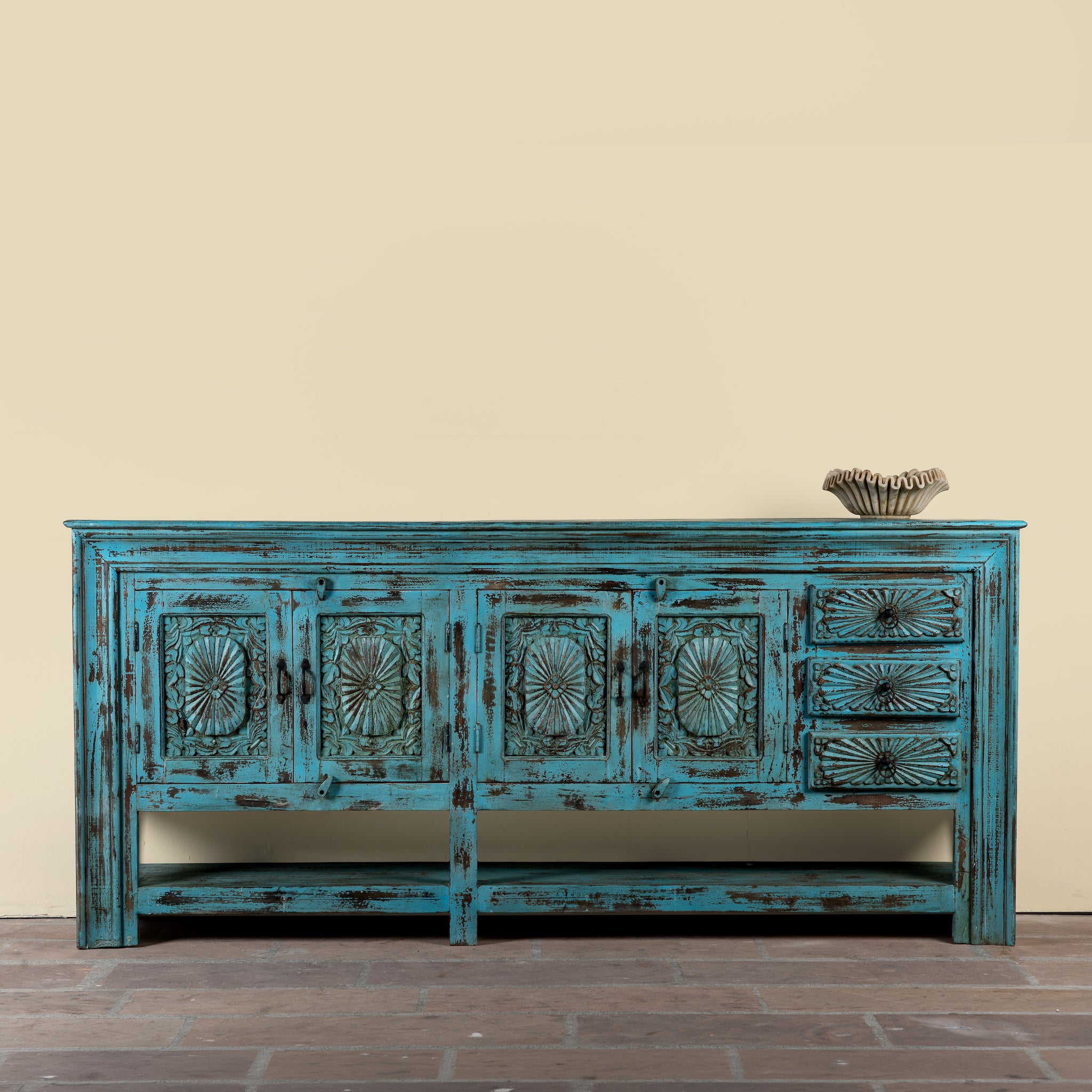 Kalpana reclaimed wood console table with blue distressed finish, carved doors, three drawers, enclosed storage and open lower shelf.