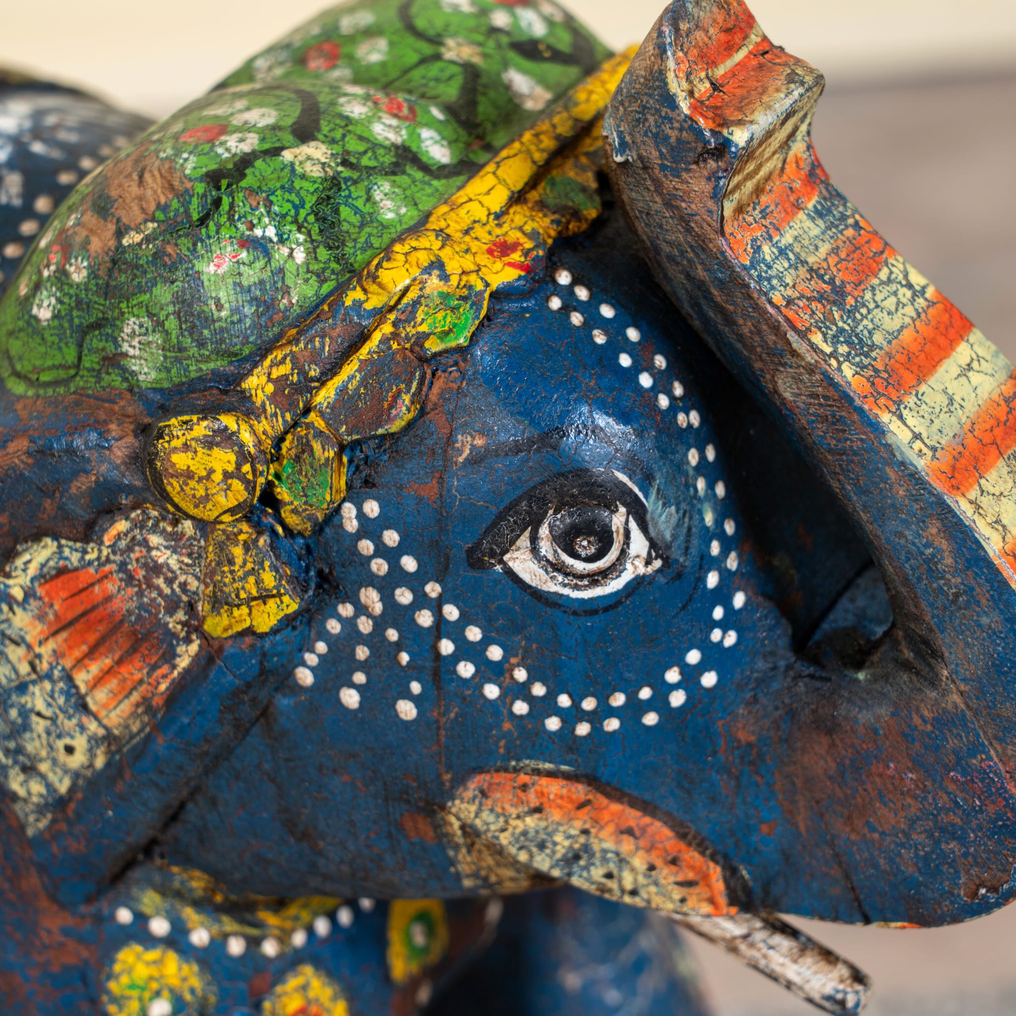 Close up image of a blue hand‑painted wooden elephant decoration with colourful folk art motifs, a unique Indian home accessory and vintage home decor accent.
