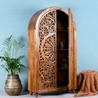 Open door image of a unique wooden wardrobe made from solid mango wood with hand-carved floral design and rounded shape, 100 × 40 × 190 cm.