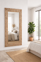 Lifestyle imagination of a carved mango wood mirror Apsara in white-washed finish with hand-carved floral design. A tall, artisan-crafted piece of Indian furniture ideal for vintage home decor and bohemian interiors.
