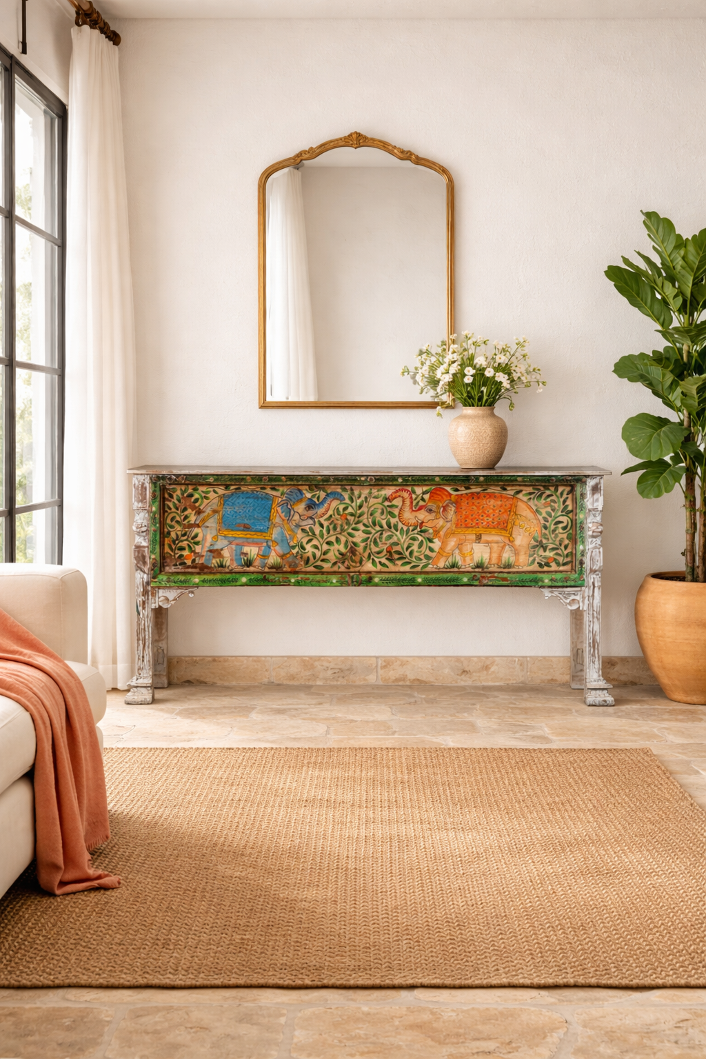 Lifestyle imagination of a hand-painted console table Caara made from reclaimed wood with vibrant elephant motifs and green foliage. A unique furniture piece full of vintage flair for bohemian interiors.