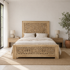 Panel bed Nidhi made from solid mango wood with tall carved headboard, shown in sandblasted bleached finish. A handcrafted piece of bedroom furniture inspired by beds from India.