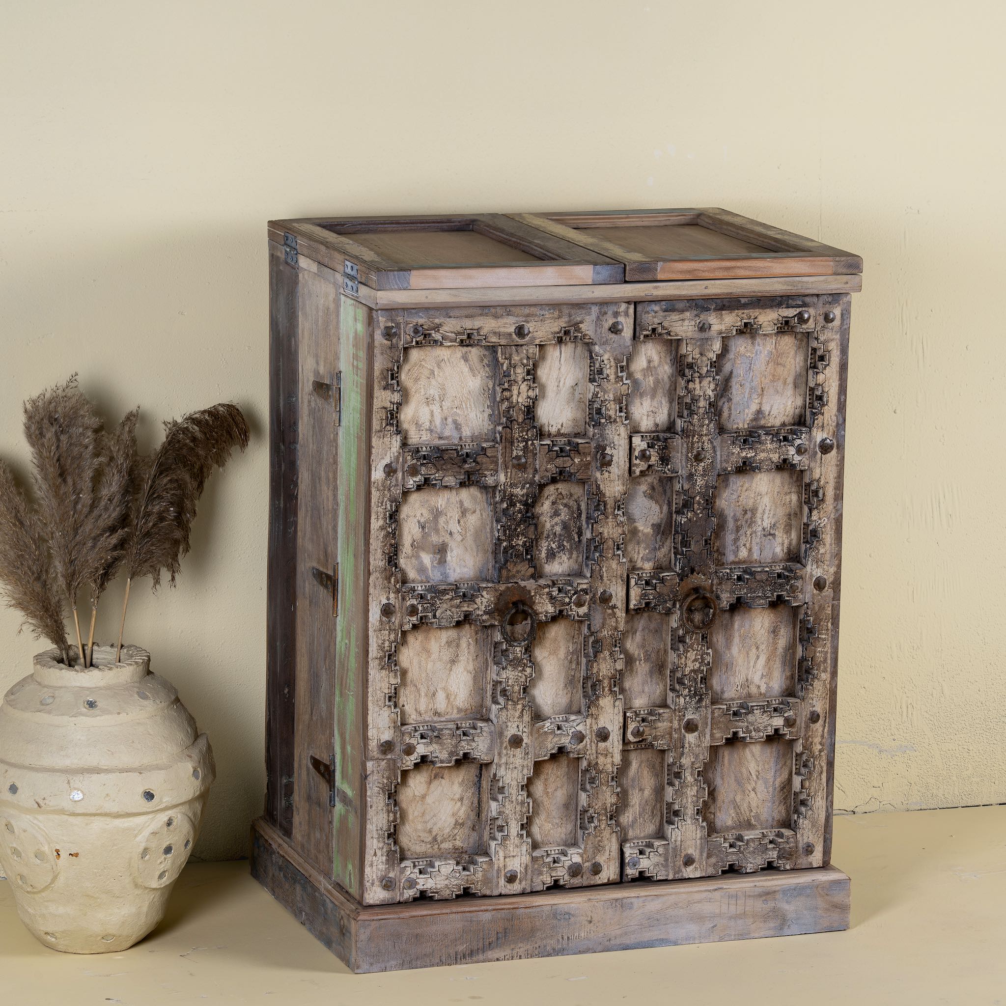 Foldable bar table made of reclaimed teak wood with inside storage and old door front.