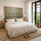 Lifestyle image of a Cauvery hand painted head board made from an antique Indian teak door, featuring traditional floral motifs in blue and cream and original iron hardware—an elegant example of hand painted head boards and authentic Indian headboards.