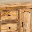 Close up image of a sideboard made of natural mango wood with 2 doors, 4 compartments and 2 drawers. 