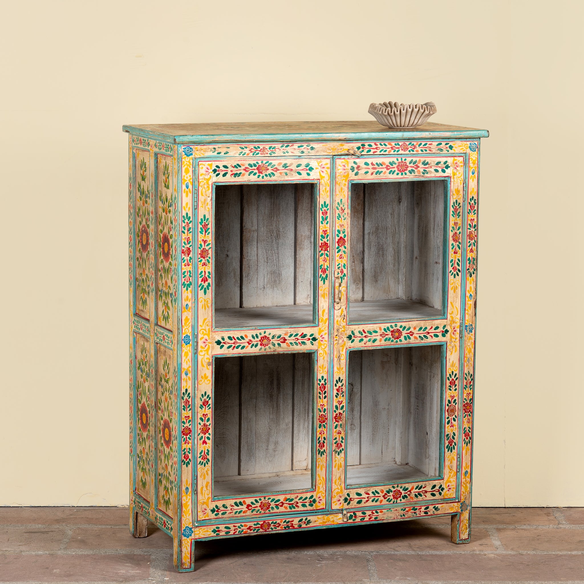 Side angle image of a Chaitanya hand-painted reclaimed wood display cabinet with colourful floral design 112cm