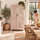 Lifestyle image of a hand carved mango wood wardrobe in floral design with ample storage in ibiza style.