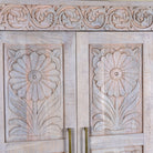 Close up image of a hand carved mango wood wardrobe in floral design with ample storage in ibiza style.