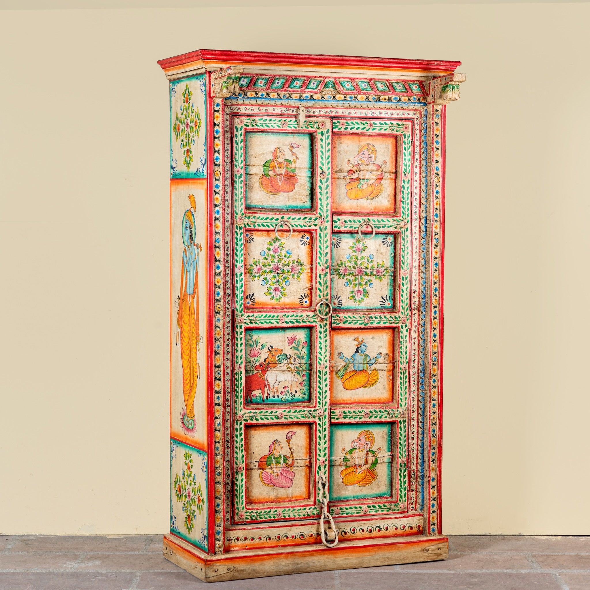 Side angle image of a antique hand painted wardrobe made from reclaimed teak wood with Indian motifs; unique furniture and teak wood furniture, 113 × 50 × 190 cm.