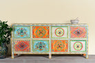 Image of a hand painted sideboard with 8 drawers made of natural mango wood; artisanal chest for bohemian interior, 200 × 40 × 90 cm.