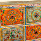 Close up image of a hand painted sideboard with 8 drawers made of natural mango wood; artisanal chest for bohemian interior, 200 × 40 × 90 cm.