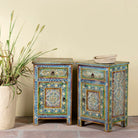 Side angle image of a pair of hand-painted nightstands made of reclaimed wood in boho style, sustainable furniture with drawer and cabinet, 45 × 35 × 70 cm.