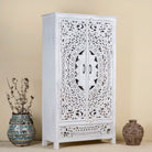 Side angle image of a hand-carved mango wood wardrobe with floral and geometric patterns and white-washed finish – carved wooden furniture for boho chic and Mediterranean-inspired interiors.