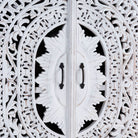 Close up image of a Hand-carved mango wood wardrobe with floral and geometric patterns and white-washed finish – carved wooden furniture for boho chic and Mediterranean-inspired interiors.