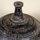 Close up image of a hand-painted clay vase with rounded body, narrow neck and iron stand, handcrafted decorative vase with rustic aged finish, 40cm.