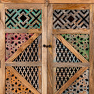Close up image of a handmade mango wood cabinet with carved floral and geometric lattice doors, distressed colour accents; artisanal furniture perfect for boho style interiors, 100 × 45 × 130 cm.