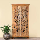Lifestyle image of a hand-carved mango wood cupboard with Indian peacock design motifs, Mediterranean-style wardrobe; elegant mango wood furniture, 190 × 100 × 40 cm.
