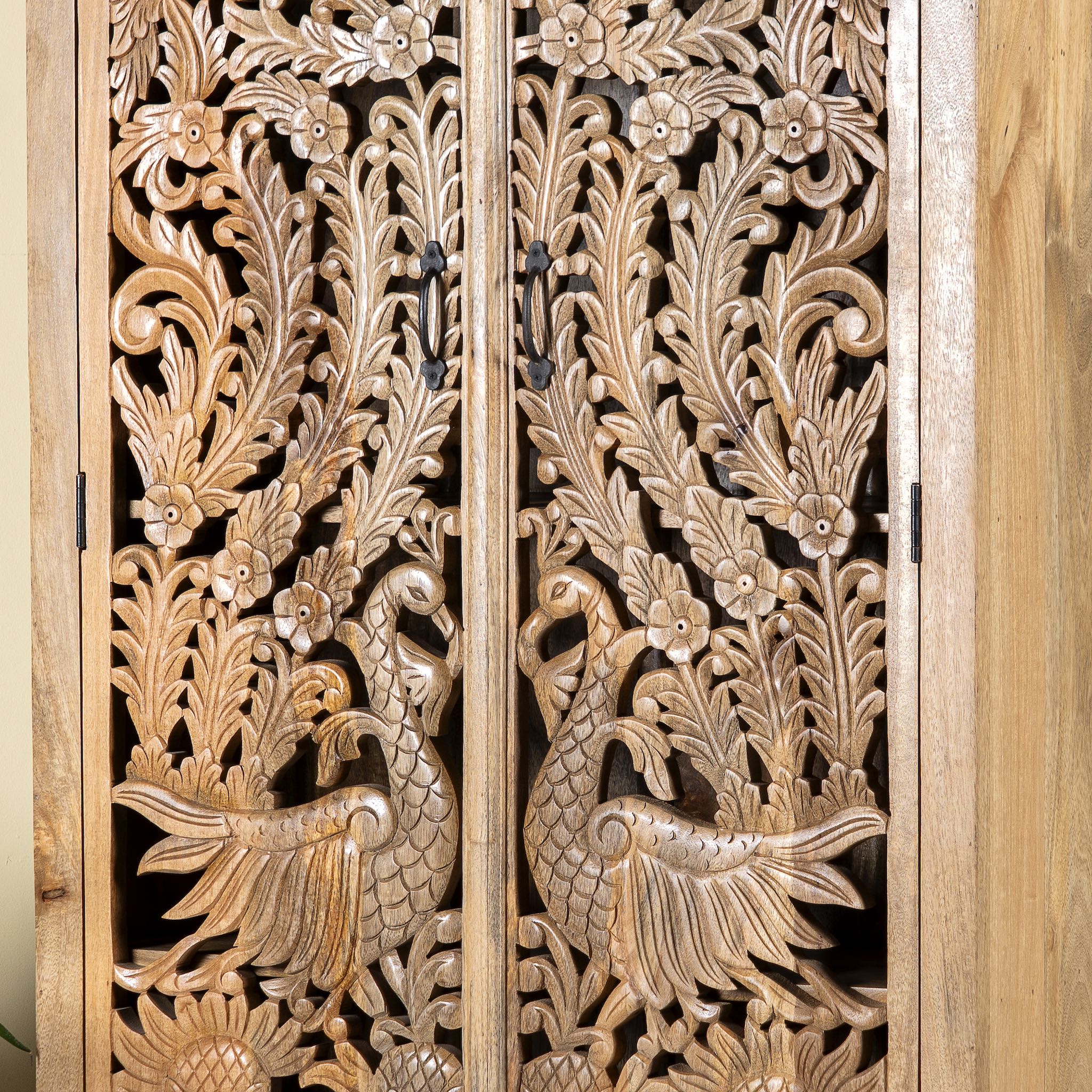 Close up image of a hand-carved mango wood cupboard with Indian peacock design motifs, Mediterranean-style wardrobe; elegant mango wood furniture, 190 × 100 × 40 cm.