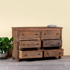 Side angle image with open drawers of a chest of 6 drawers in Japandi style made of reclaimed dark wood.