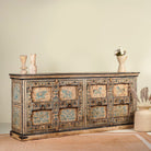 Side angle image of a unique sideboard made of recycled wood with hand painted Indian motifs in blue and gold; sustainable furniture for dining rooms or hallways, 220 × 44 × 98 cm.