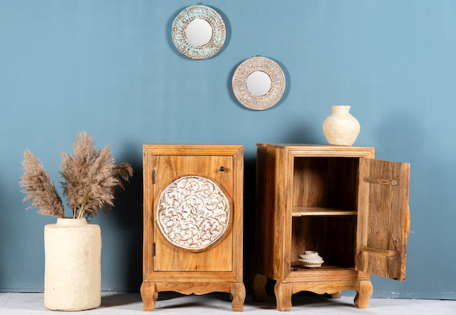 Side angle image with open door of a whitewashed mango wood nightstand with hand-carved floral door – a handcrafted example of carved wooden furniture ideal for rustic and vintage bedrooms.