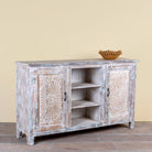 Side angle image of a Devesh reclaimed wood sideboard with hand carved refurbished doors, open shelves and vintage whitewash finish 153cm