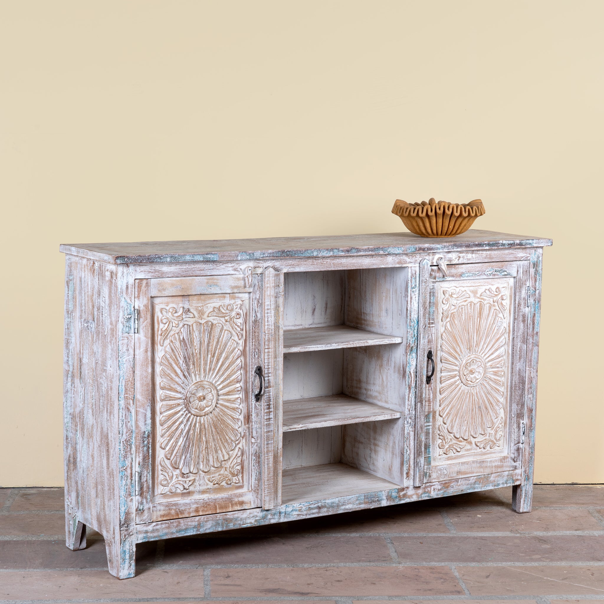 Side angle image of a Devesh reclaimed wood sideboard with hand carved refurbished doors, open shelves and vintage whitewash finish 153cm
