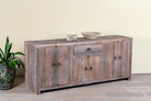 Side angle image of a reclaimed wood sideboard Devina in rustic minimalistic style with cabinet doors and central drawer. A sustainable furniture piece showcasing natural wood grain and timeless simplicity.