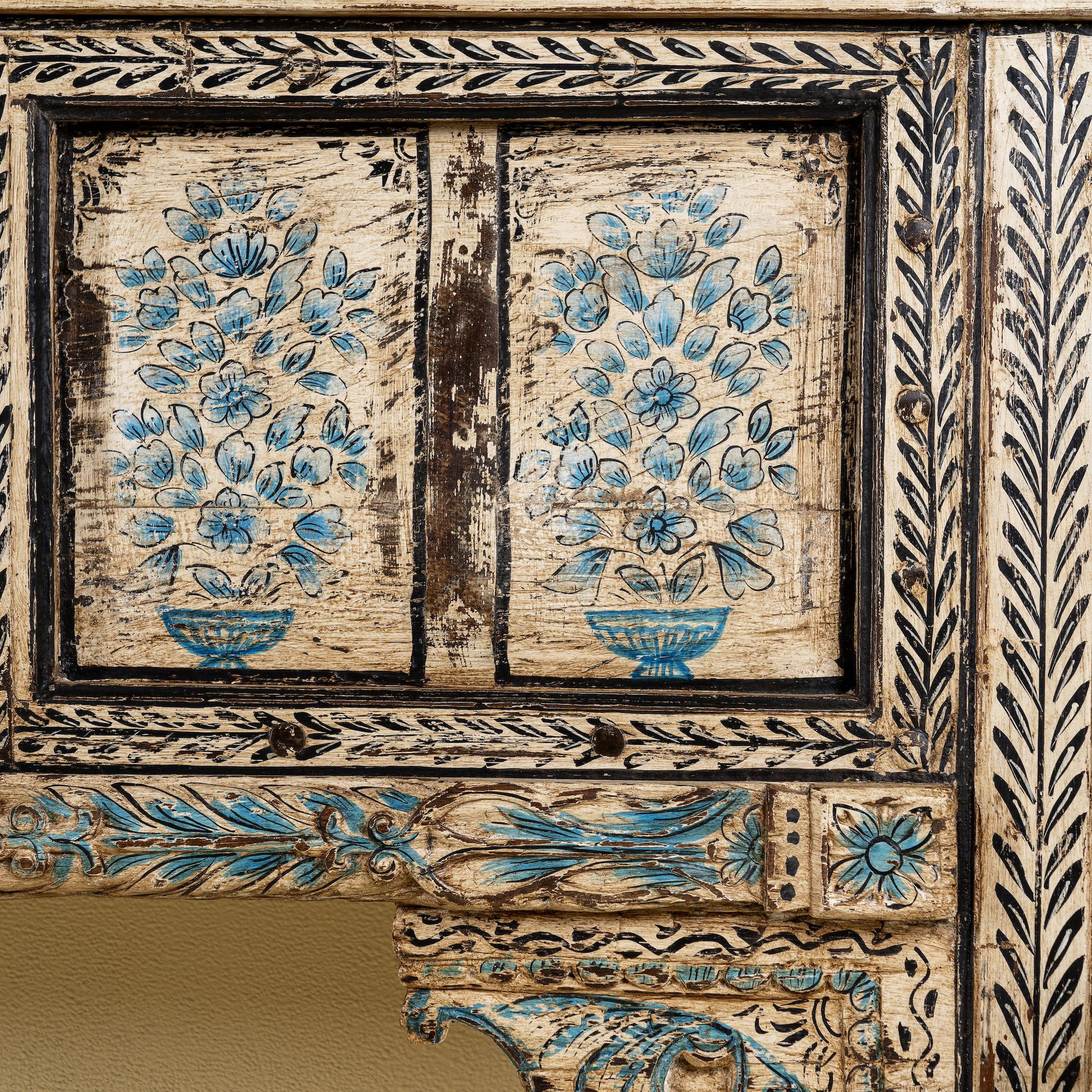 Close up image of a  hand painted console table in reclaimed teak with floral motifs and antique distressed finish, 197 × 40 × 82 cm.