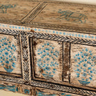 Close up side image of a hand painted console table in reclaimed teak with floral motifs and antique distressed finish, 197 × 40 × 82 cm.