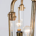 Close up image of a large round pendant lamp in antique brass with test tube glass – minimalistic style pendant light combining vintage metal lighting and elegant glass accents.